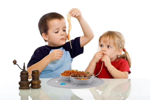 Enfants qui prennent leur repas dans une assiette en silicone
