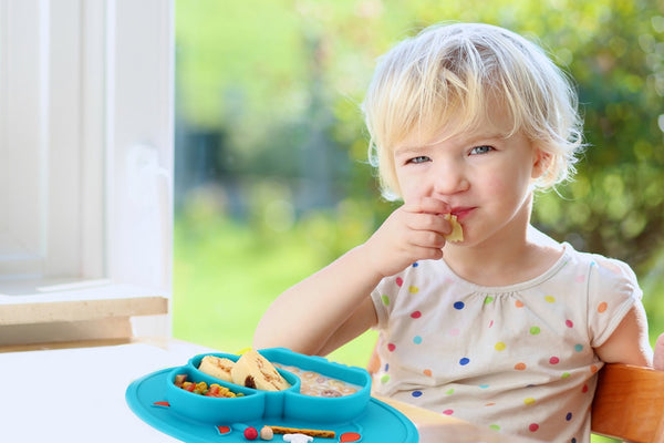 Enfant qui prend son repas dans une assiette en silicone